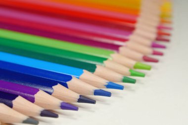 Yeni ahşap renkli gökkuşağı renginde kalemler, tamamen sivriltilmiş, masanın üzerinde yatıyor.