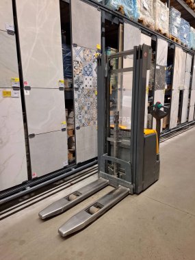 İnşaat hipermarketinde forklift mal satışı arasında duruyor.