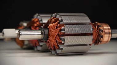 İki perküsyon masaj aleti ve mutfak blendırı gibi küçük ev aletlerinden bakır bobinli elektrikli motorların pervaneleri veya armatürleri. Üç pervane beyaz masada yatıyor.