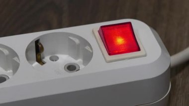 Fiş kırmızı güç göstergesiyle beyaz elektrik prizine yerleştiriliyor.