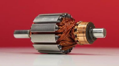 Küçük ev aletlerindeki bakır bobinli elektrikli motordan armatür veya rotor kırmızı arka planda döner