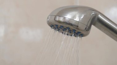 Duş al. Banyoda duş başlığı. Duş başlığından su akıyor.