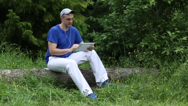 Homme avec ordinateur tablette dans la forêt — Video