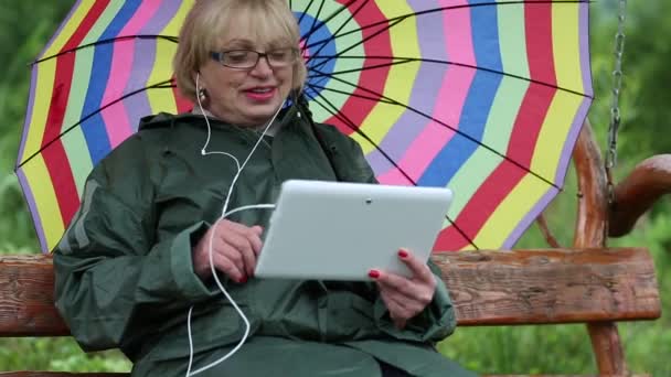 Mujer con paraguas se comunica a través de tableta PC — Vídeos de Stock