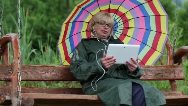 Vrouw met multicolor paraplu en gadget — Stockvideo