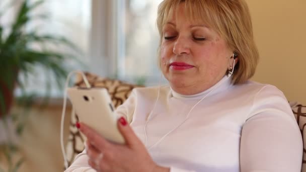 Женщина со смартфоном и слушает музыку — стоковое видео