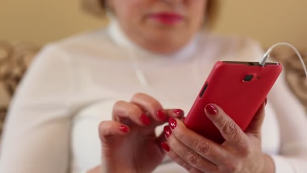 Женские руки с красным смартфоном — стоковое видео