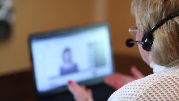 Mujer con auriculares en conversaciones de ordenador — Vídeo de stock