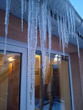 Özel evin çatısından sarkan büyük buz sarkıtları