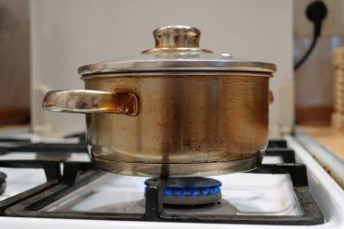 Tencere, gaz sobasının üstünde. Yemek pişirmek. Et pişiyor.