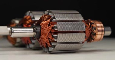 İki perküsyon masaj aleti ve mutfak blendırı gibi küçük ev aletlerinden bakır bobinli elektrikli motorların pervaneleri veya armatürleri. Üç pervane beyaz masada yatıyor.