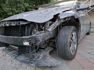 Kazadan sonra siyah bir araba. Yolcu vagonu enkaz durumda.