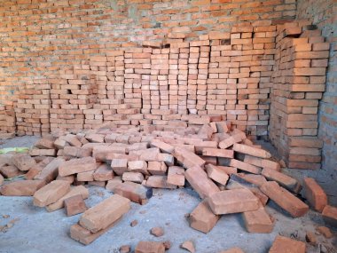 Tuğlalar yere saçılmış. Bitmemiş bir kulübenin içi. Yerleşim olmayan, tamamlanmamış bir bina.