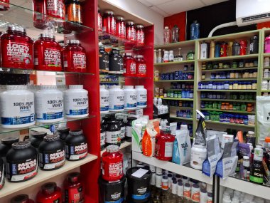 KYIV, UKRAINE, 15 Temmuz 2025: Dükkandaki raflarda çeşitli spor beslenme ürünleri. İçinde proteinler, amino asitler, vitaminler, mineraller ve diğer yararlı spor ürünleri olan bir sürü plastik kavanoz ve paket.