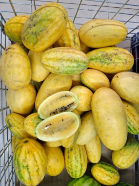 Sarı karpuz. Süpermarket raflarında sebzeler. Karpuz ve kavun karışımı. Markette taze sebzeler. Market tezgahları olgun mevsimlik sebzelerle doludur.