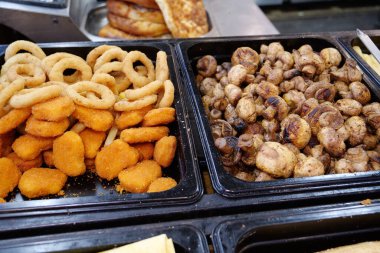 Patates kızartması, kızarmış patates. Kızarmış şampiyon mantarı. Fast food restoranındaki çeşitli yiyecekler.