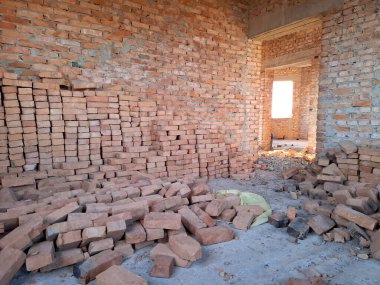 Tuğladan duvarları olan bitmemiş bir kulübenin içi. Yerleşim olmayan, tamamlanmamış bir bina.