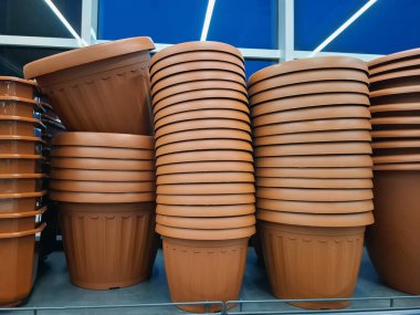 Plastik saksılar bir çiçekçide satılır. Süpermarket raflarında büyük saksılar