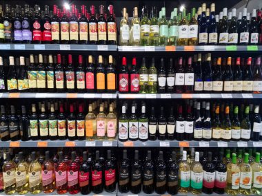 KYIV, UKRAINE, Kasım 7, 2025: Süpermarket raflarında farklı alkollü ürünler. Birçok alkollü içecek şişesi bir mağazanın alkollü içecekler bölümünde raflarda duruyor.