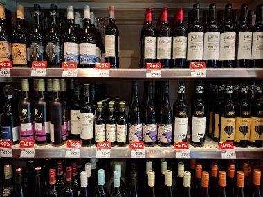 KYIV, UKRAINE, Kasım 7, 2025: Süpermarket raflarında farklı alkollü ürünler. Birçok alkollü içecek şişesi bir mağazanın alkollü içecekler bölümünde raflarda duruyor.