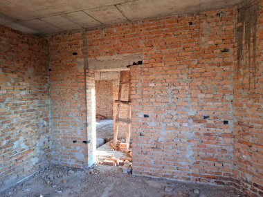 Tuğladan duvarları olan bitmemiş bir kulübenin içi. Yerleşim olmayan, tamamlanmamış bir bina.