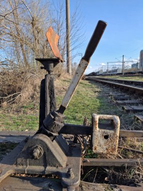 Demiryolunu değiştirmek için ok. Demir yolu anahtarı, kaldıraç ve ağırlık dengeleyici. Demiryolu raylarını çevirmek için eski bir mekanizma. Demiryolu nokta anahtarı mekanik manuel demiryolu katılımı oku için demiryolunda.