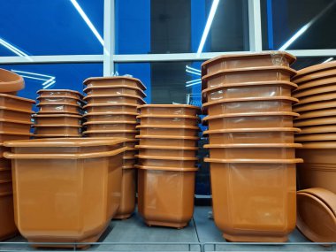 Süpermarket raflarında bir sürü büyük kahverengi saksı var. Plastik saksılar çiçekçide satılır.