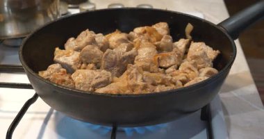Gaz ocağında tavada kızaran et.