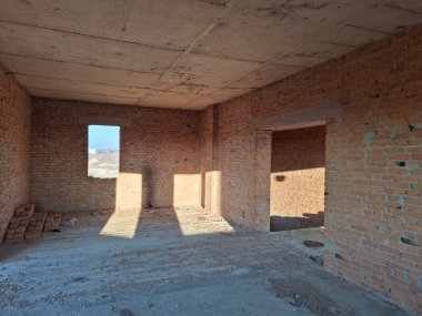 Tuğladan duvarları olan bitmemiş bir kulübenin içi. Yerleşim olmayan, tamamlanmamış bir bina.