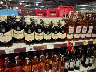 KYIV, UKRAINE, Kasım 7, 2025: Süpermarket raflarında farklı alkollü ürünler. Birçok alkollü içecek şişesi bir mağazanın alkollü içecekler bölümünde raflarda duruyor.