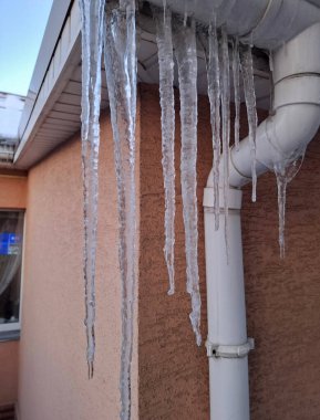 Kır evinin çatısından sarkan büyük buz sarkıtları