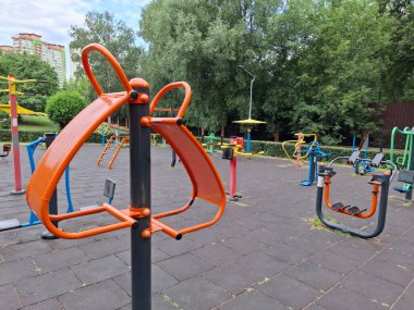 Şehir parkındaki açık hava spor sahası. Fiziksel aktivite için renkli egzersiz ekipmanları