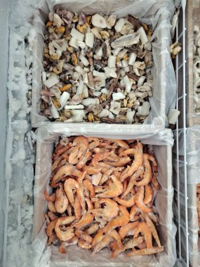 Bir markette dondurulmuş kırmızı karides ve diğer deniz ürünleri.