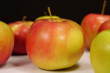 Siyah arkaplanda taze kırmızı ve sarı elmalar
