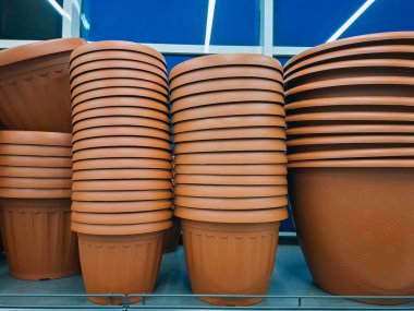 Plastik saksılar bir çiçekçide satılır. Süpermarket raflarında büyük saksılar