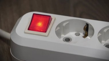 Güç adaptörü kırmızı enerjili ve göstergeli elektrikli portatif sokete yerleştiriliyor