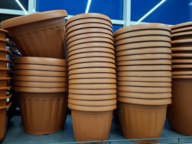 Plastik saksılar bir çiçekçide satılır. Süpermarket raflarında büyük saksılar