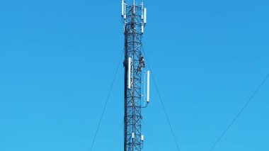 İki tamirci bir baz istasyonuna hizmet ediyor, yeni kablo ve ekipman yüklüyorlar. Yüksek irtifa işi. İşçiler baz istasyonunu onarıyor. Cep telefonu kulesindeki işçiler. İşteki bakım personeli