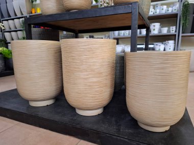Süpermarket raflarında büyük seramik saksılar. Çiçekçide birçok büyük seramik ürünler