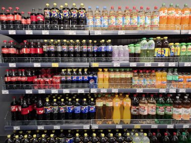KYIV, UKRAINE, 6 Aralık 2025: bir süpermarkette karbonatlı içecekler. Birçok karbonatlı içecek şişesi marketteki raflarda duruyor.