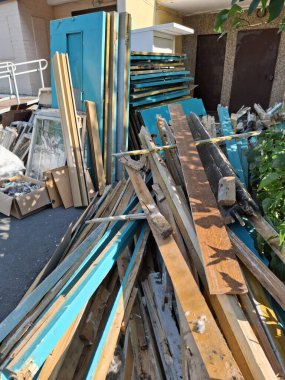 Yurtiçi binadaki eski kapı ve pencerelerin tamamen değişmesi. Eski ahşap kapılar apartmanın girişinin yanında duruyor. Yeni plastik pencere ve kapılarla değiştir