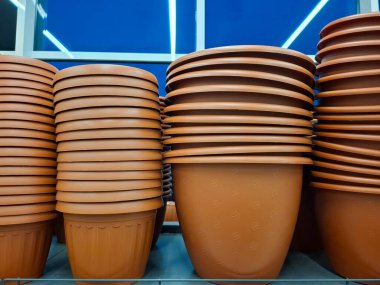 Çiçekçide plastik saksılar. Süpermarket raflarında büyük saksılar