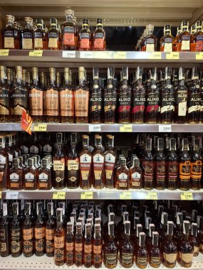 KYIV, UKRAINE, Kasım 7, 2025: Süpermarket raflarında farklı alkollü ürünler. Birçok alkollü içecek şişesi bir mağazanın alkollü içecekler bölümünde raflarda duruyor.