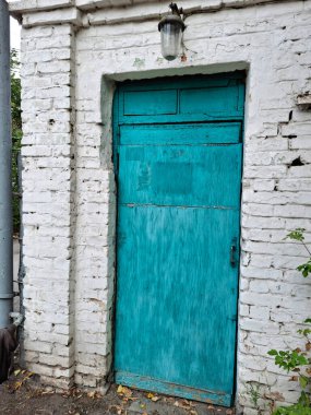 Beyaz tuğla duvarlar eski mavi ahşap kapıyı çerçeveliyor