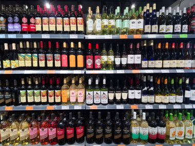 KYIV, UKRAINE, Kasım 7, 2025: Süpermarket raflarında farklı alkollü ürünler. Birçok alkollü içecek şişesi bir mağazanın alkollü içecekler bölümünde raflarda duruyor.
