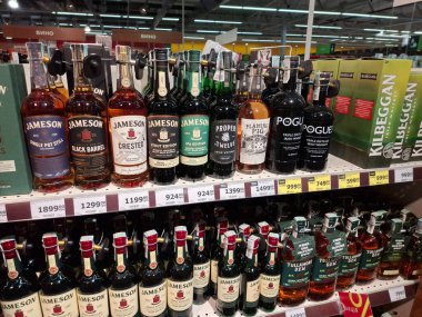 KYIV, UKRAINE, Kasım 7, 2025: Süpermarket raflarında farklı alkollü ürünler. Birçok alkollü içecek şişesi bir mağazanın alkollü içecekler bölümünde raflarda duruyor.