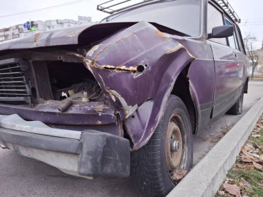 Kazadan sonra kaza yapmış mor bir yolcu arabası.