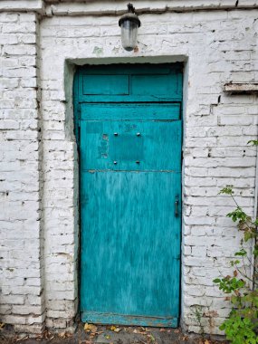 Beyaz tuğla duvar eski mavi kapıyı çevreledi
