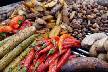Çeşitli kızarmış sıcak yiyecekler. Kırmızı biber, kabak, patates, sosis ve mantar.