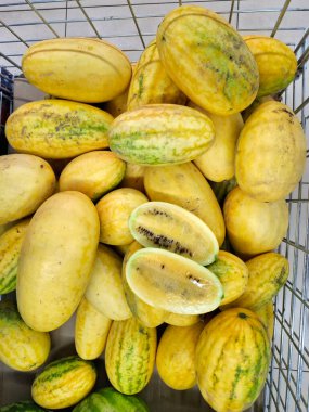 Sarı karpuz. Süpermarket raflarında sebzeler. Karpuz ve kavun karışımı. Markette taze sebzeler. Market tezgahları olgun meyve ve mevsimlik sebzelerle dolu.
